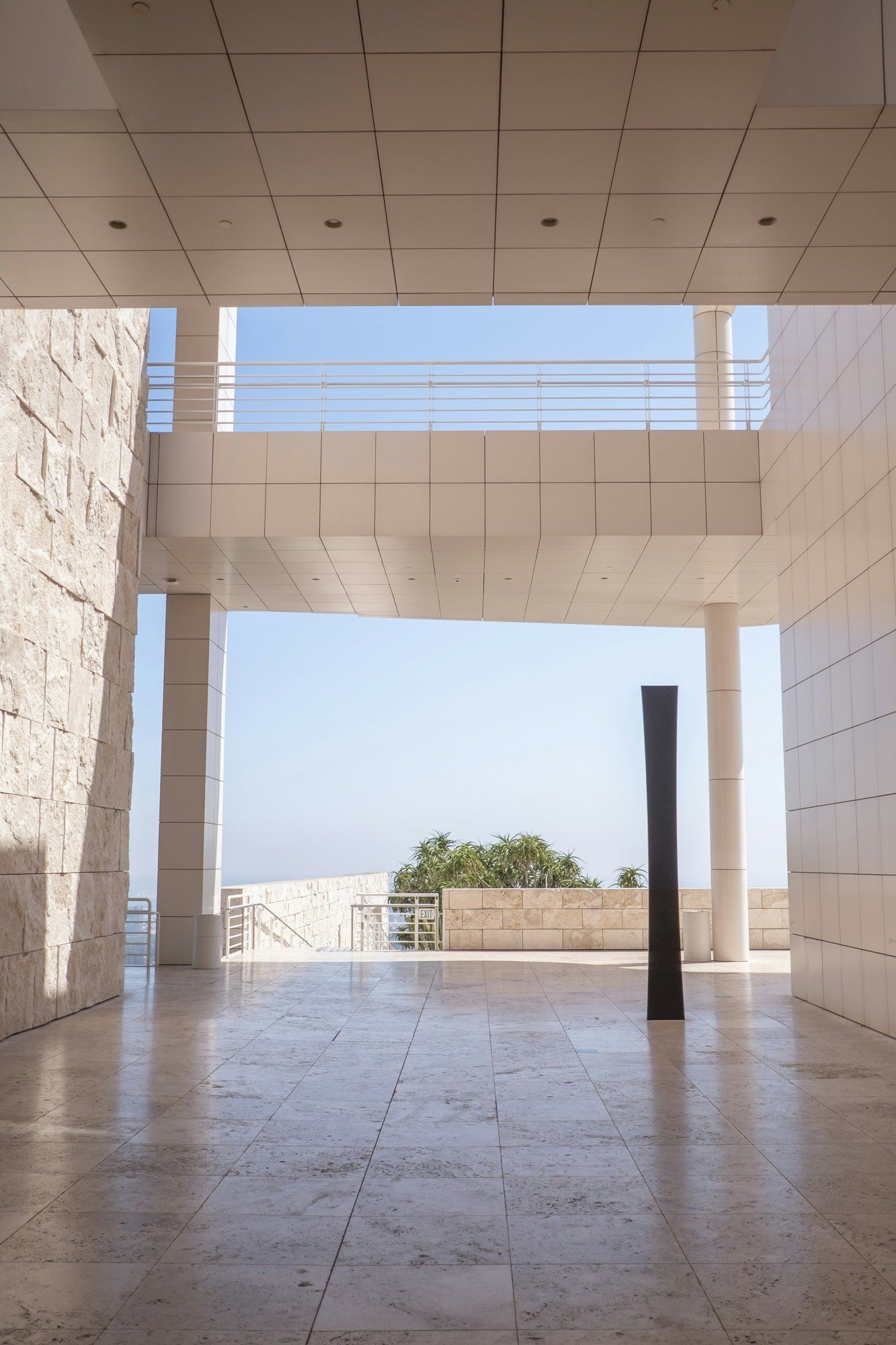 An open stone and white colonnade framing a clear sky over Los Angeles