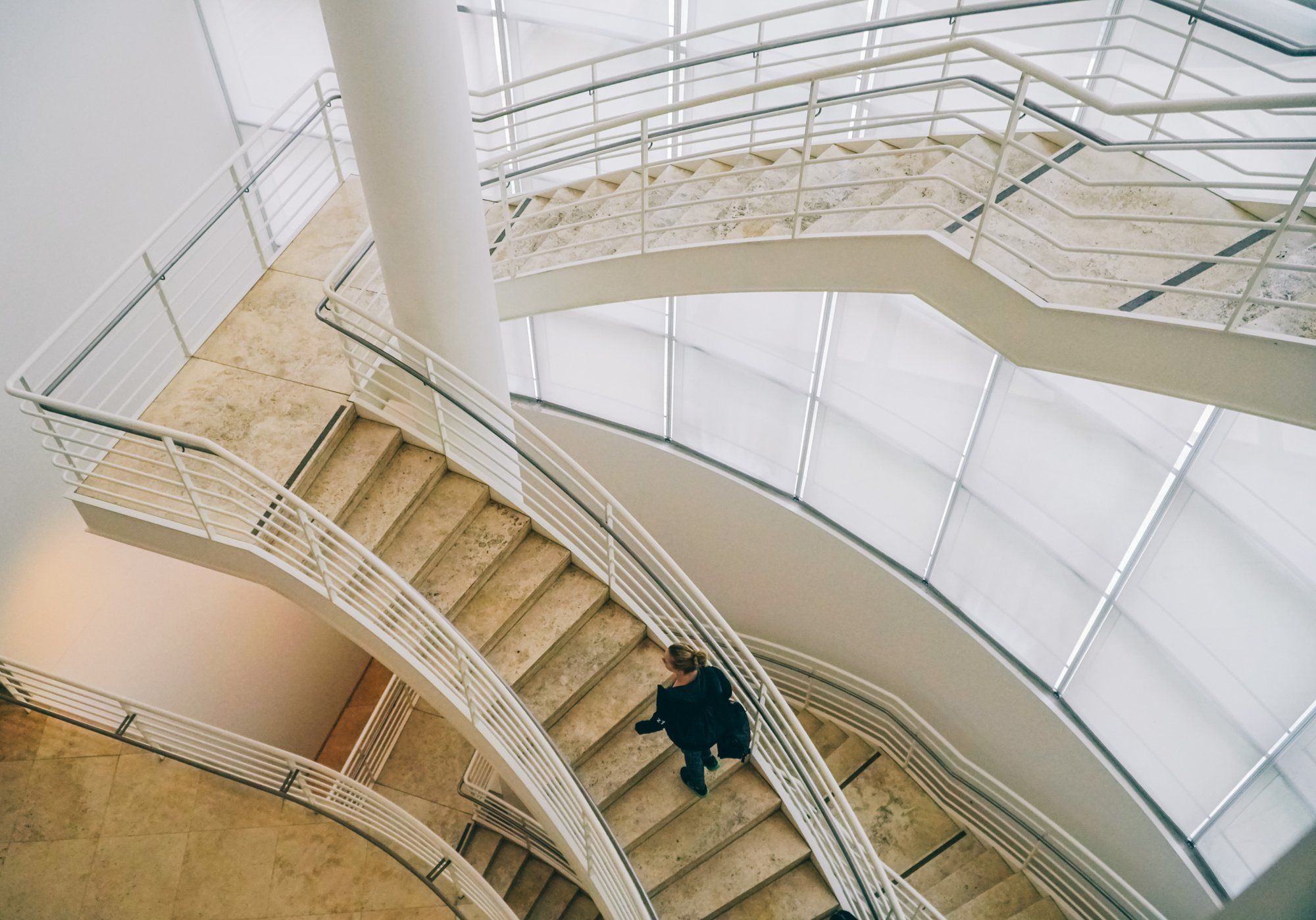 Looking down on curving stone stairs in a skylit atrium